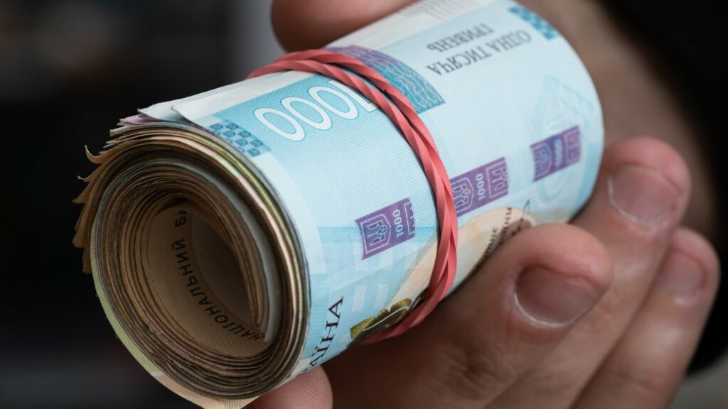 Money of Ukraine. Stack of ukrainian hryvnia banknotes in hands. Hryvnia 1000 uah